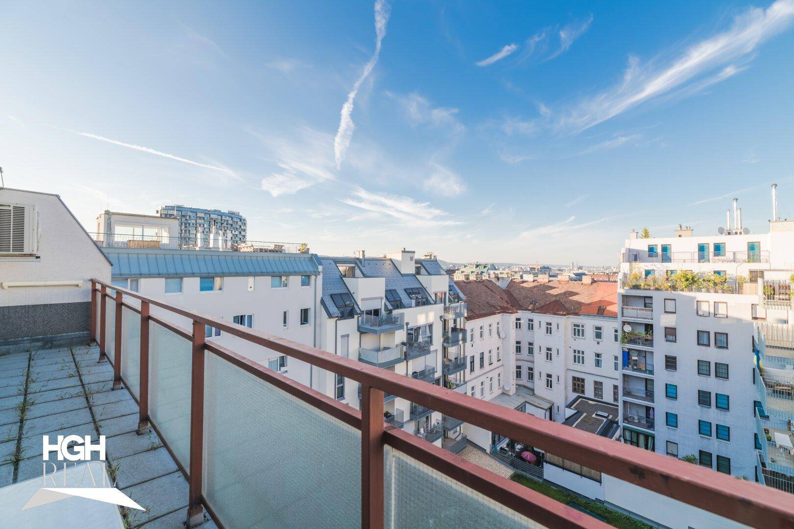 Weitläufige Dachterrasse mit Panoramablick über die Dächer der Stadt und den Himmel.
