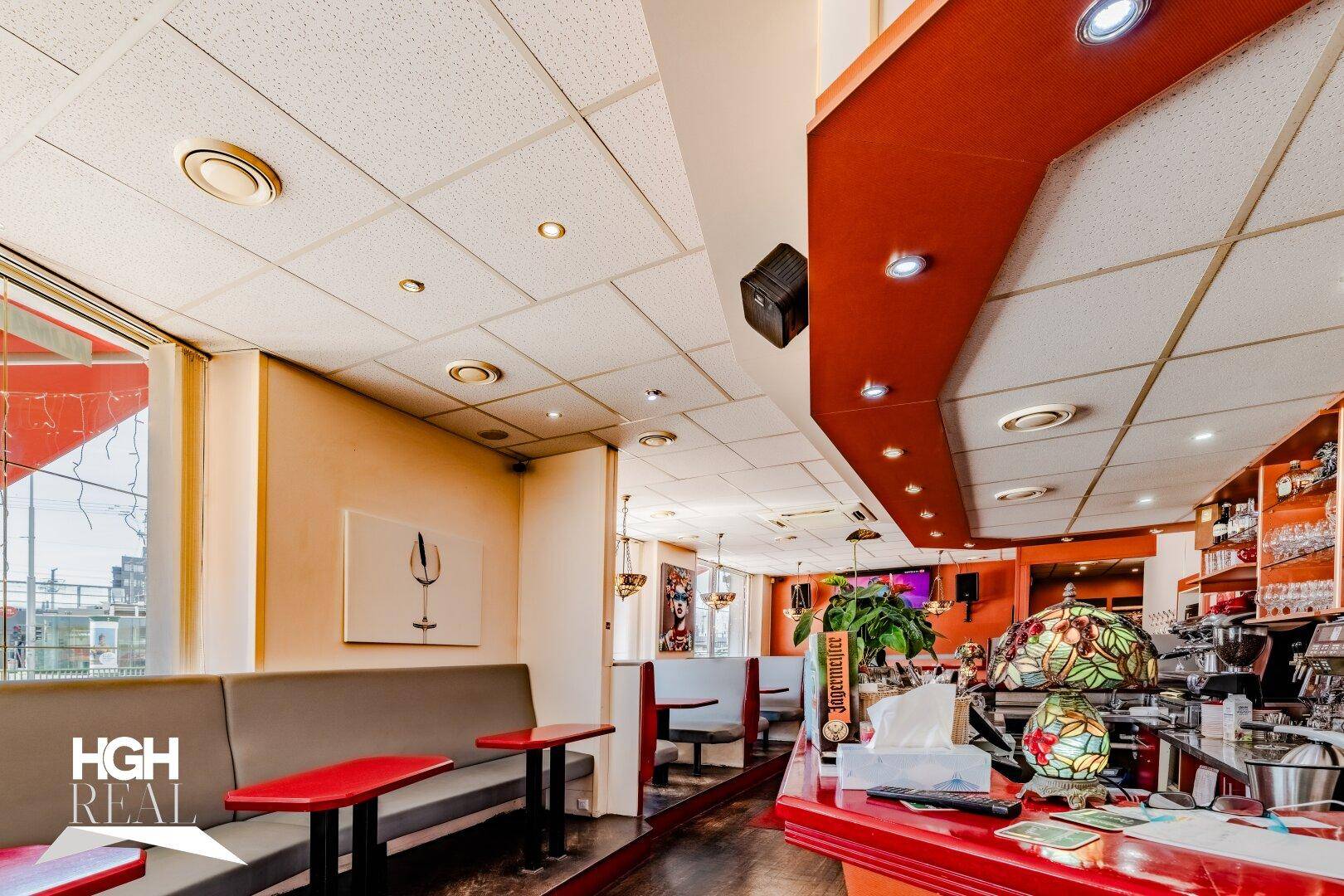Detailansicht des Barbereichs mit Kaffeemaschine, Flaschenregalen und einer dekorativen Lampe.