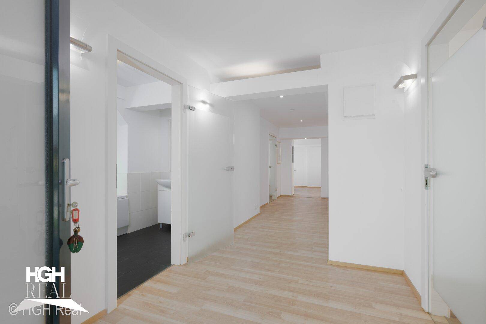 Heller Flur mit Laminatboden und Zugang zu verschiedenen Räumen.