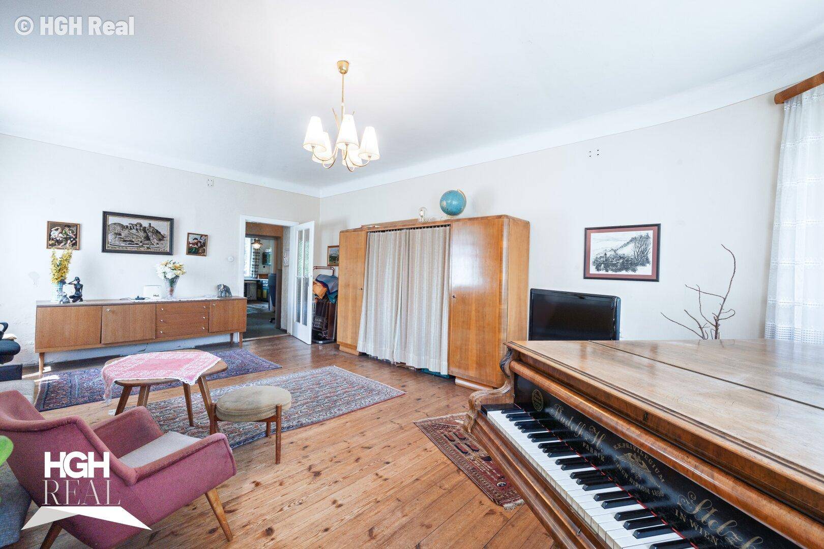 Klassisches Wohnzimmer mit Holzboden, Klavier und Vintage-Möbeln.