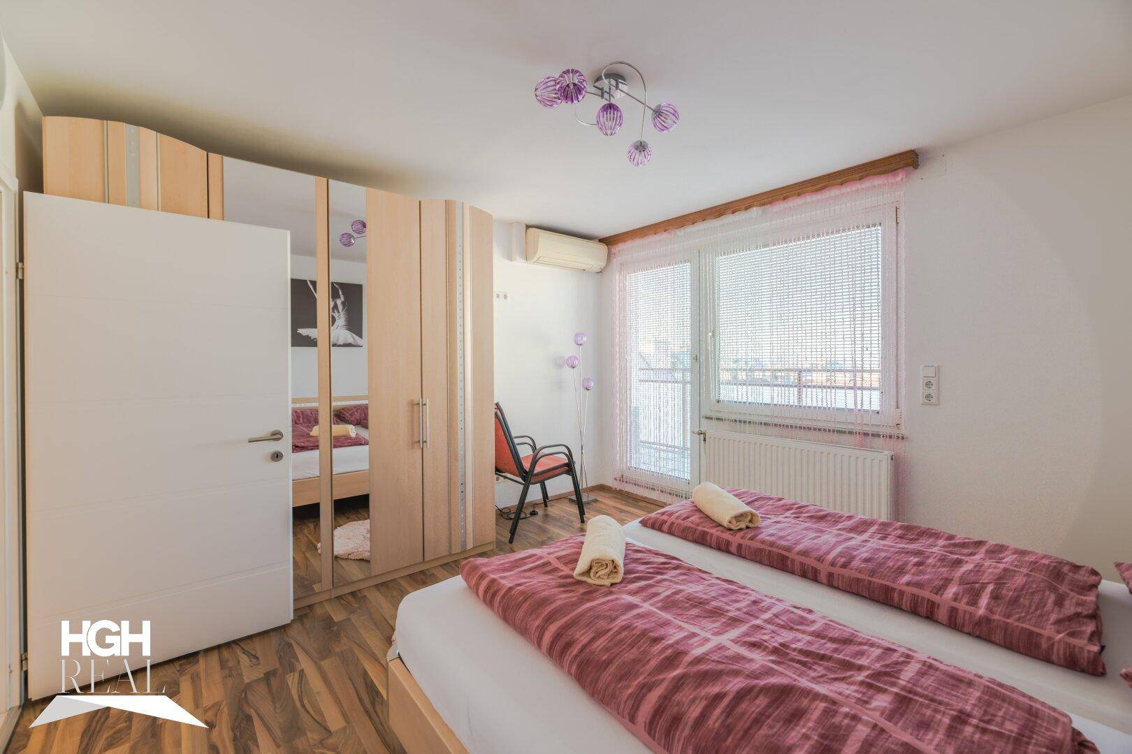 Schlafzimmer mit Spiegelschrank, zwei Einzelbetten und Klimaanlage.