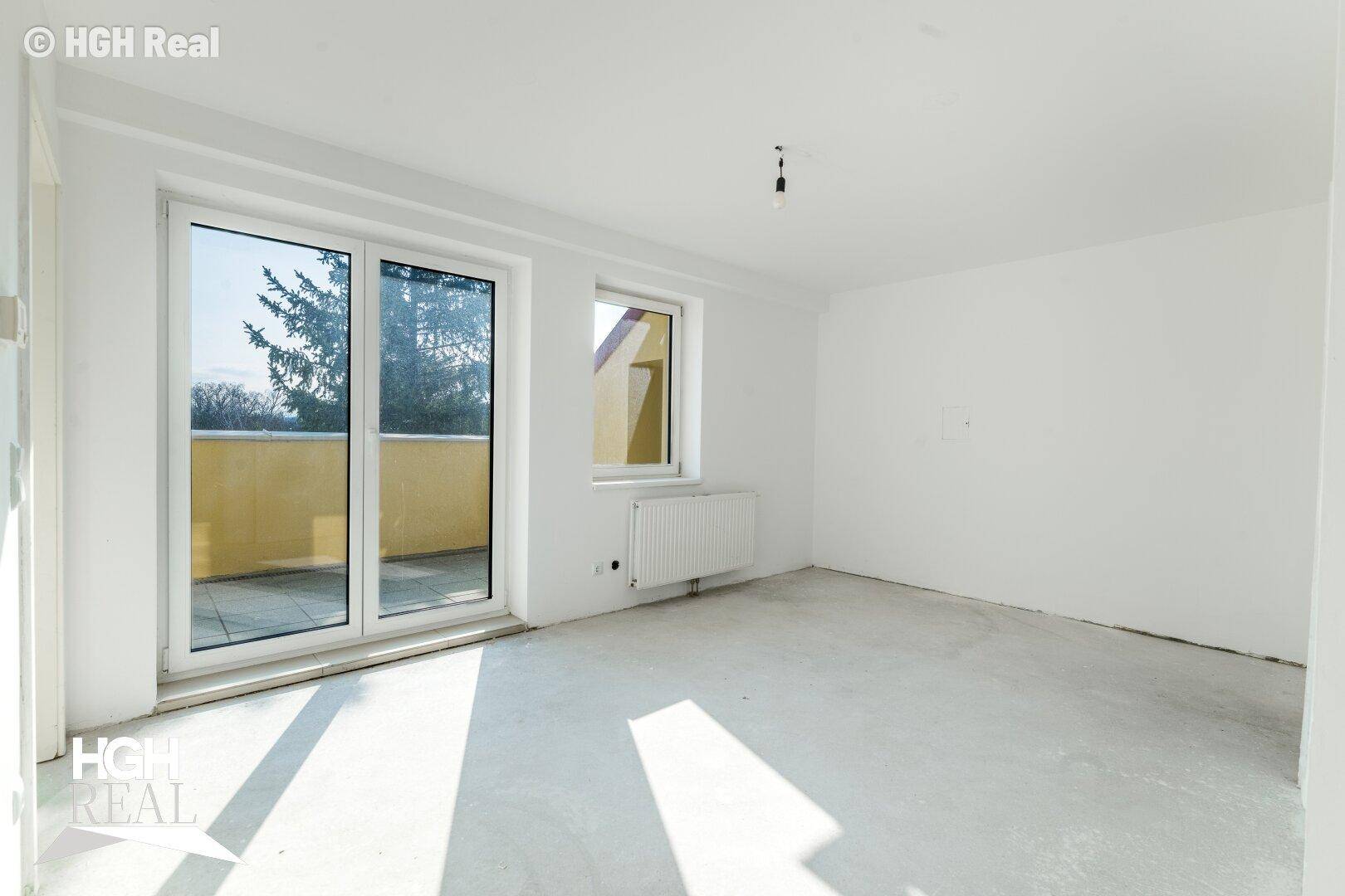 Heller Raum mit großem Schiebefenster und Zugang zu einem Außenbereich.