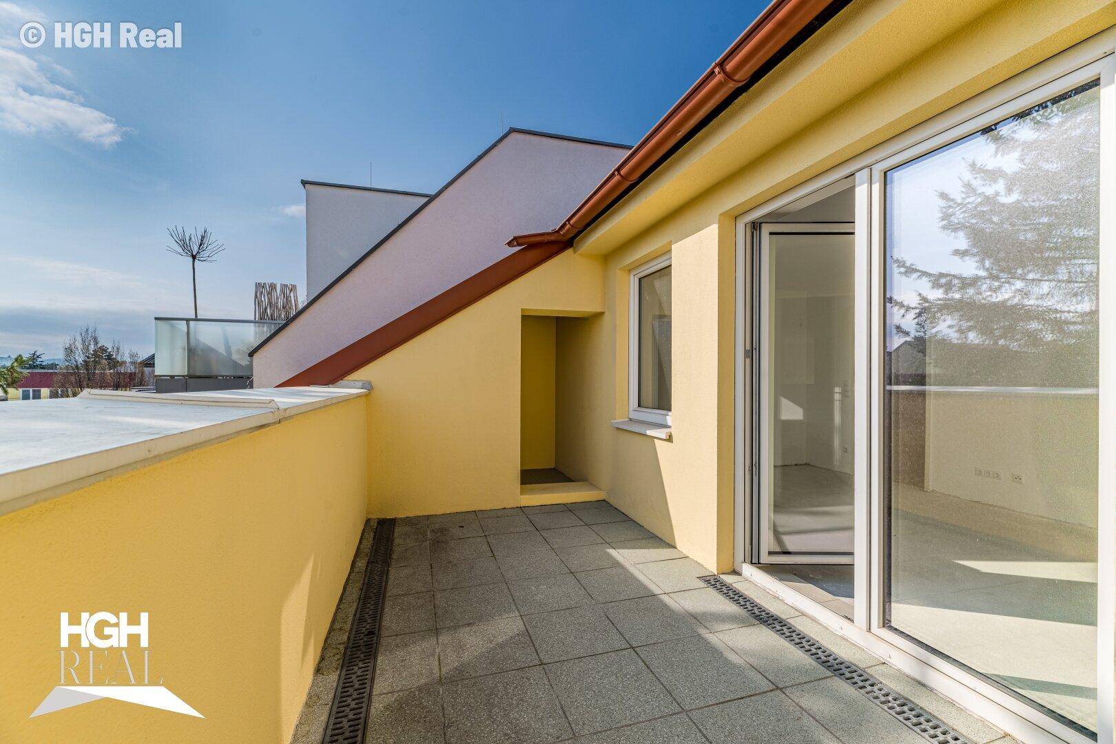 Weitläufige Dachterrasse mit gelber Brüstung und weitem Blick.