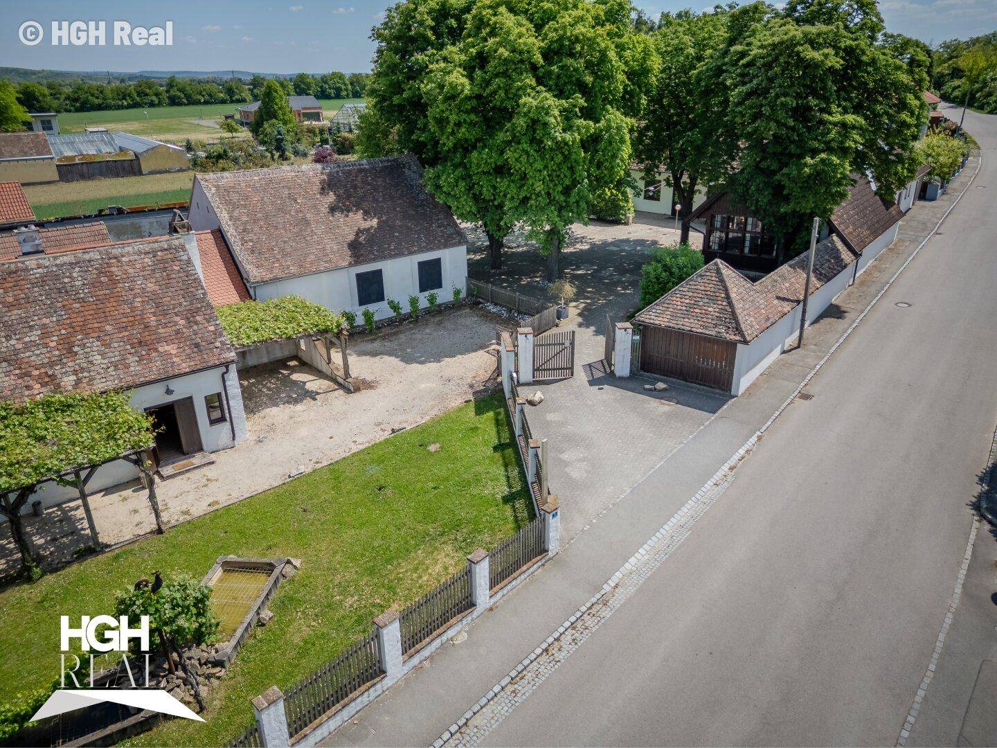 Weitläufiges Anwesen aus der Vogelperspektive mit Gebäuden, Zufahrt und angrenzender Straße.