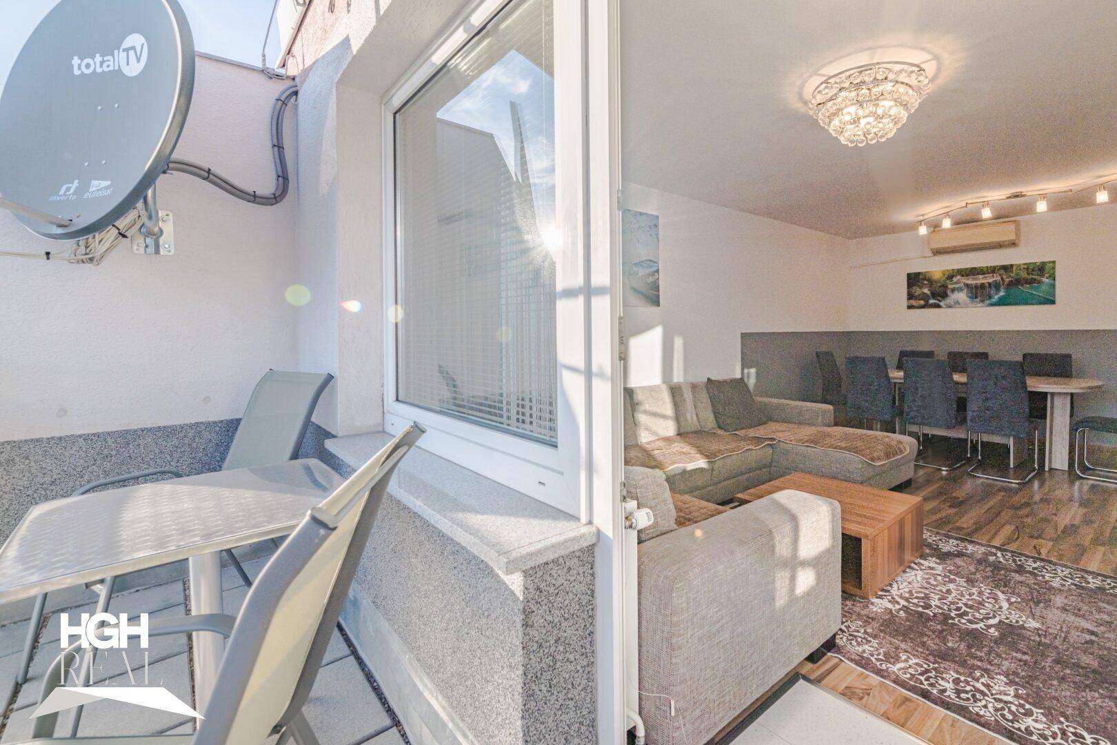 Heller Wohn- und Essbereich mit gemütlichem Sofa, Esstisch und direktem Zugang zu einem sonnigen Balkon.