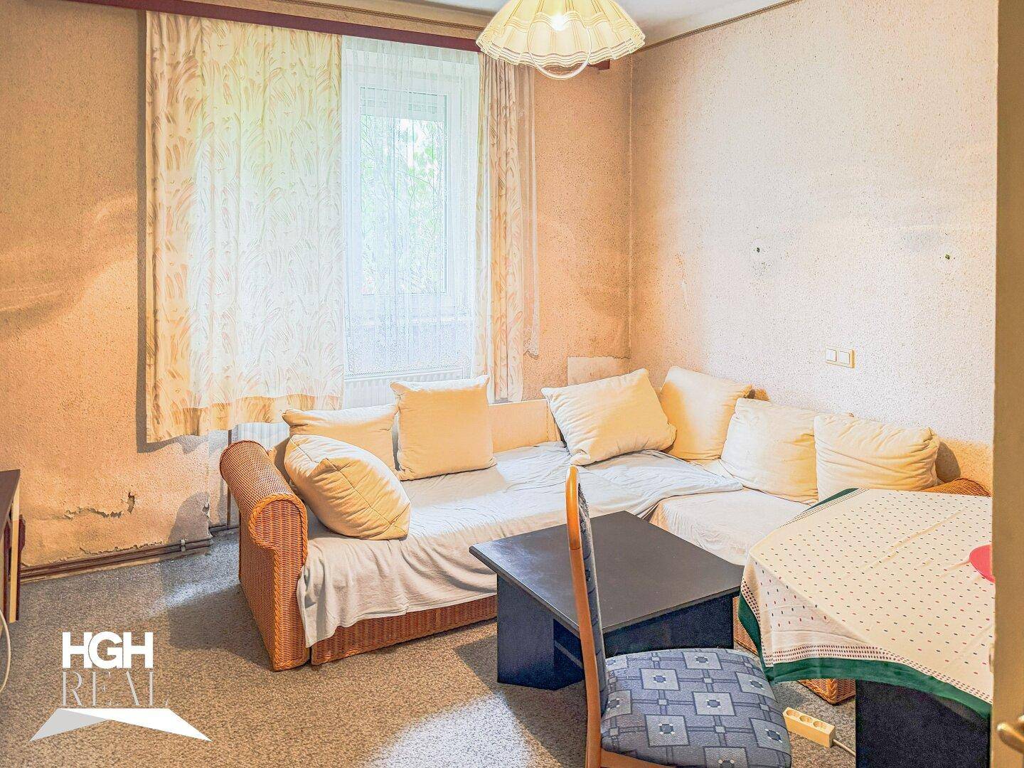 Gemütliches Wohnzimmer mit Ecksofa, Couchtisch und Teppichboden, ideal zum Entspannen.