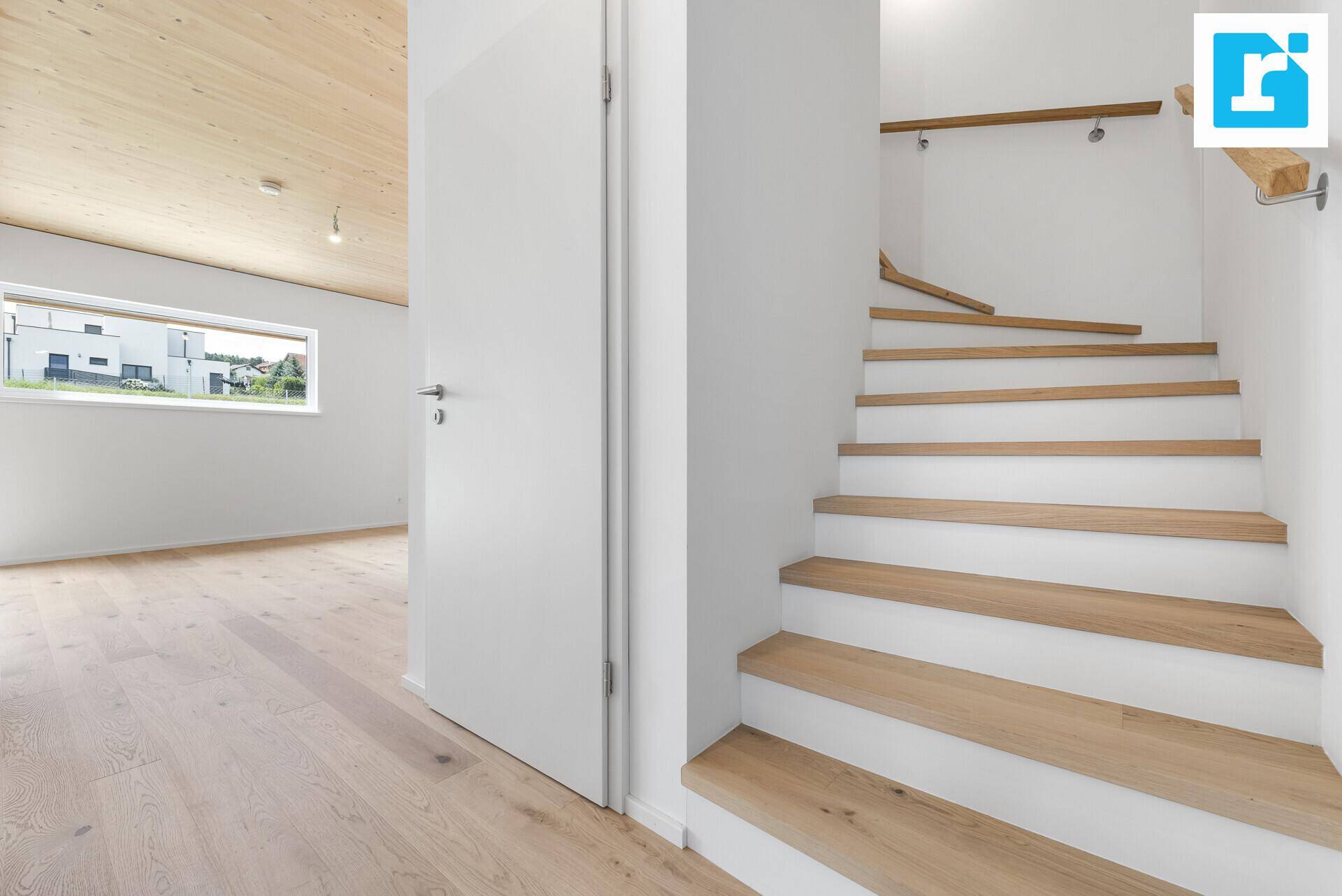 Treppenbereich mit Holzstufen und Zugang zu einem hellen Zimmer.