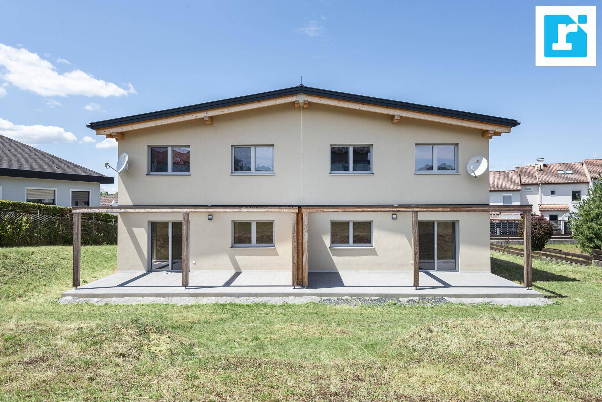 Rückseite der Doppelhaushälfte mit zwei überdachten Terrassen und Zugang zum Garten.