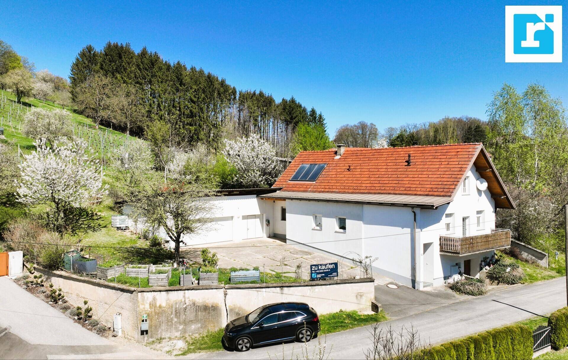 Luftaufnahme des Hauses mit großem Grundstück, Solarpaneelen und umliegender grüner Natur.