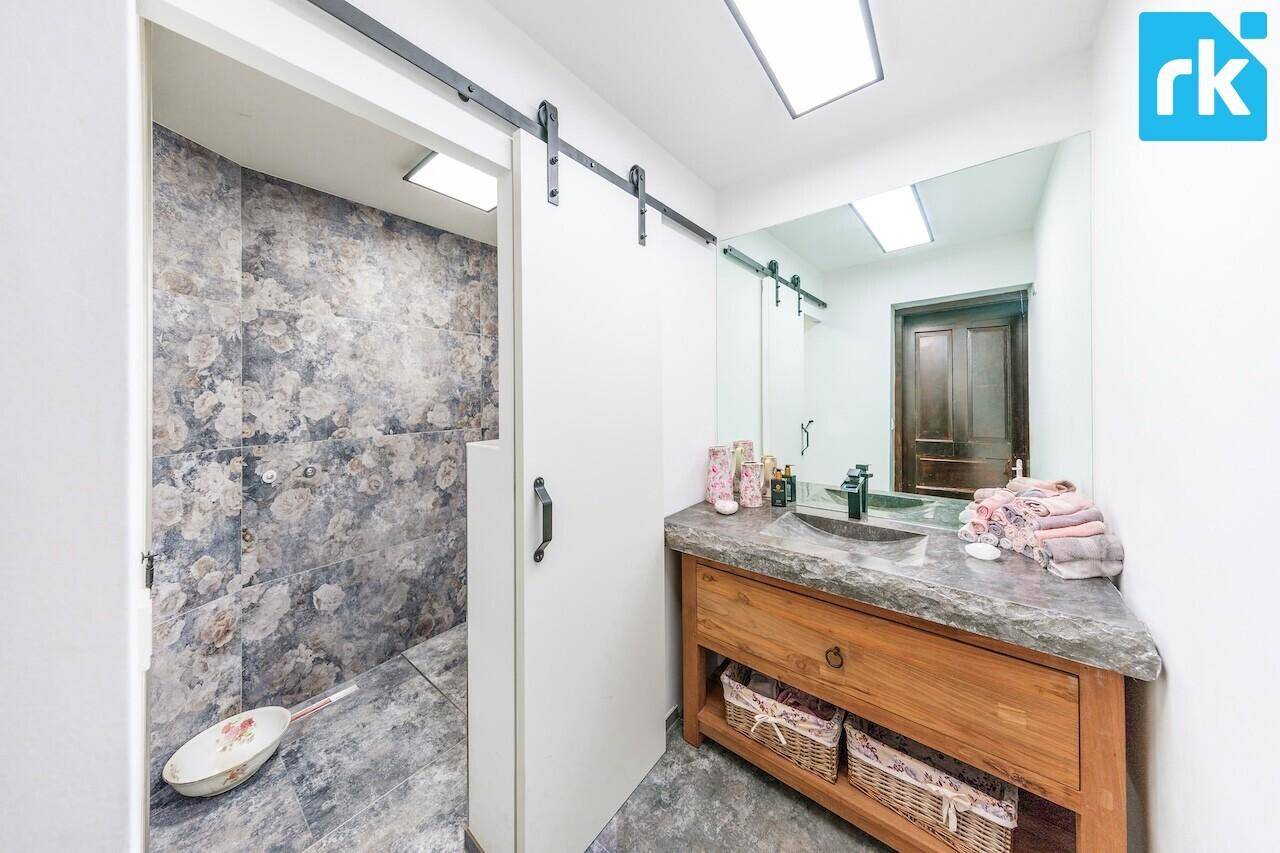 Modernes Badezimmer mit Steinarbeitsplatte, floralen Fliesen in der Dusche und Schiebetür.