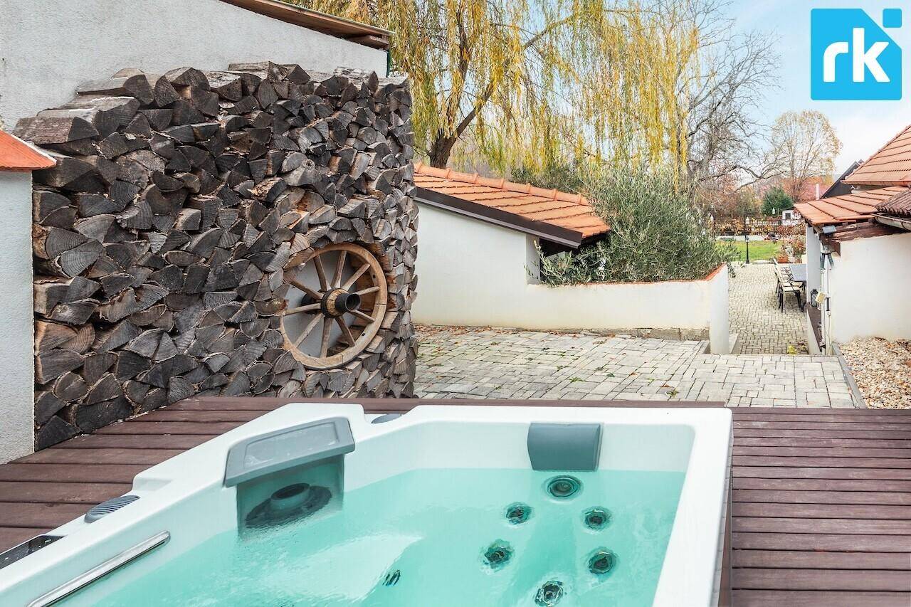 Entspannender Whirlpool auf einer Holzterrasse neben einem dekorativen Holzstapel, sehr einladend.