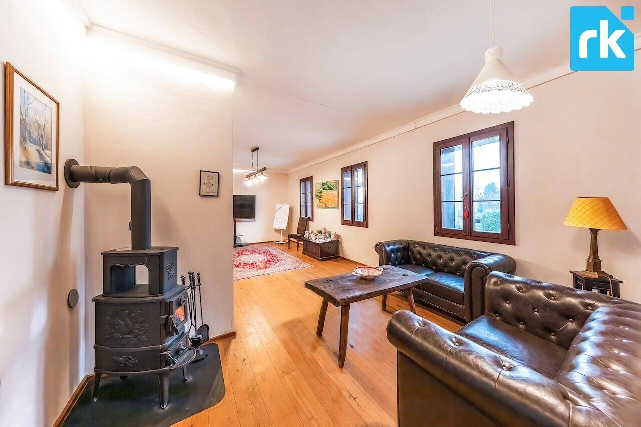Gemütliches Wohnzimmer mit Kaminofen, Ledersofas und Holzboden für entspannte Abende.