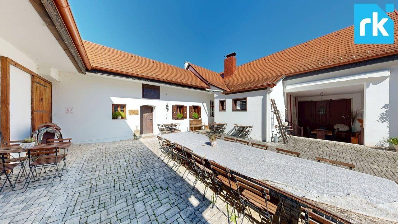 Großer Innenhof mit langer Festtafel, umgeben von traditionellen Gebäuden, ideal für Veranstaltungen.