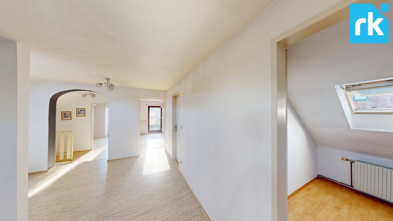 Heller Flur im Dachgeschoss mit Holzboden, Dachfenster und viel Tageslicht.