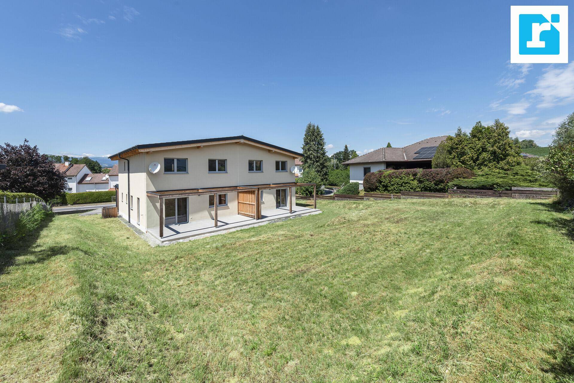 Rückansicht der Doppelhaushälfte mit weitläufigem Garten und Blick auf die Umgebung.