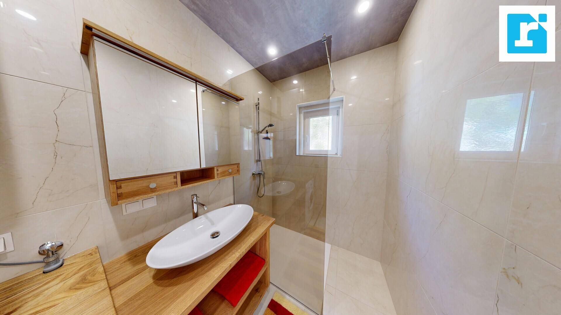 Modernes Badezimmer mit begehbarer Dusche, stilvollem Waschbecken und Holzwaschtisch.