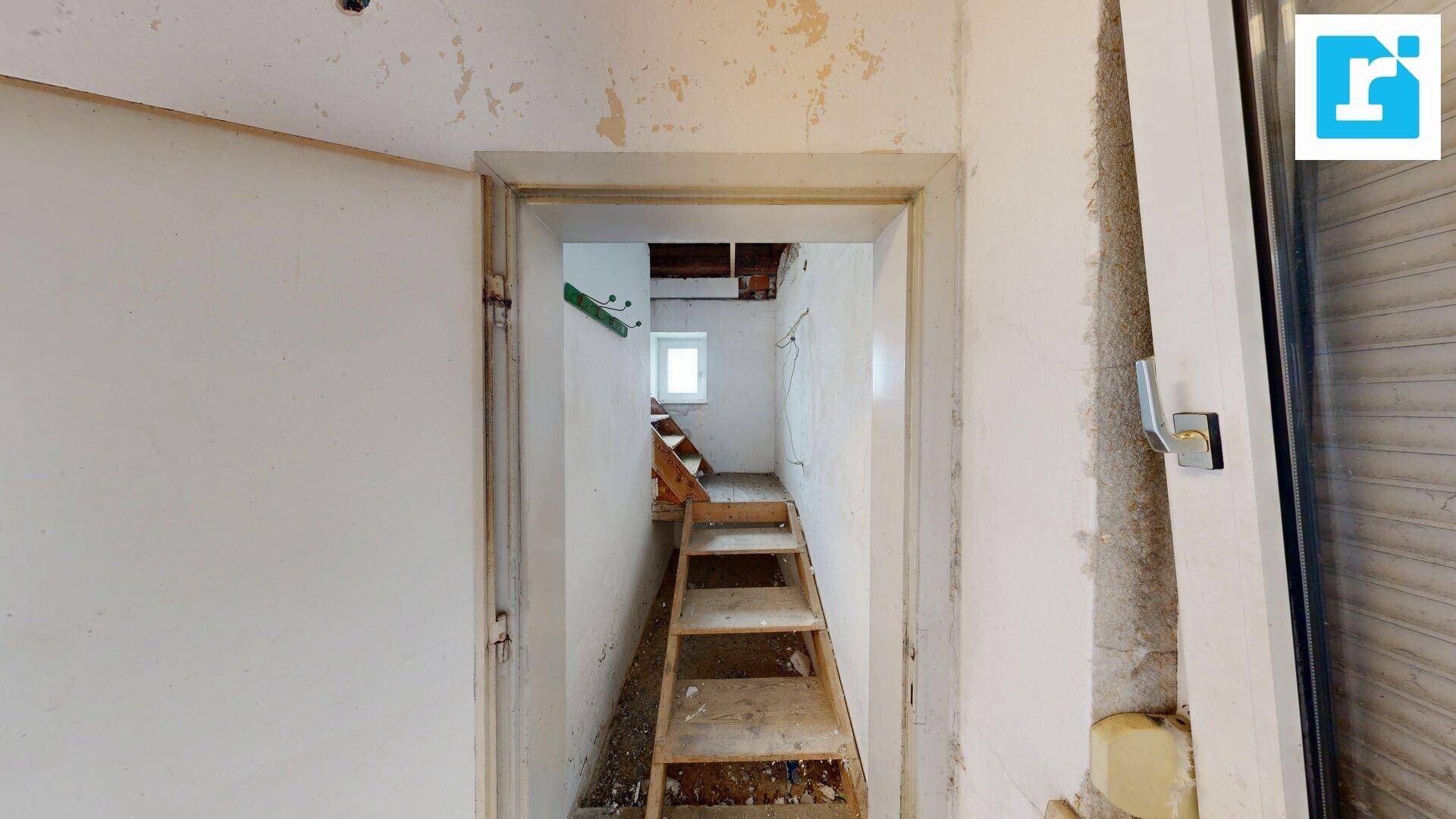 Treppe führt zu einem unfertigen Dachboden, der Ausbaupotenzial bietet.