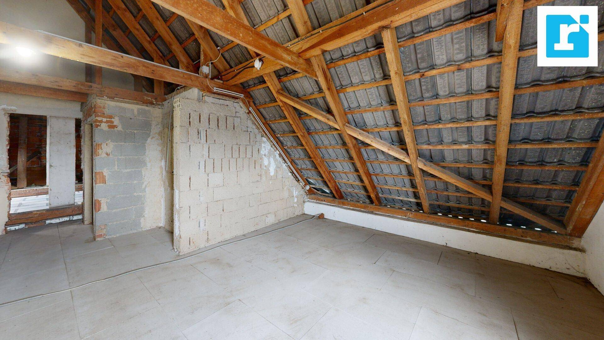 Unausgebauter Dachboden mit Holzdachstuhl und Ziegelwänden, bietet viel Potenzial.