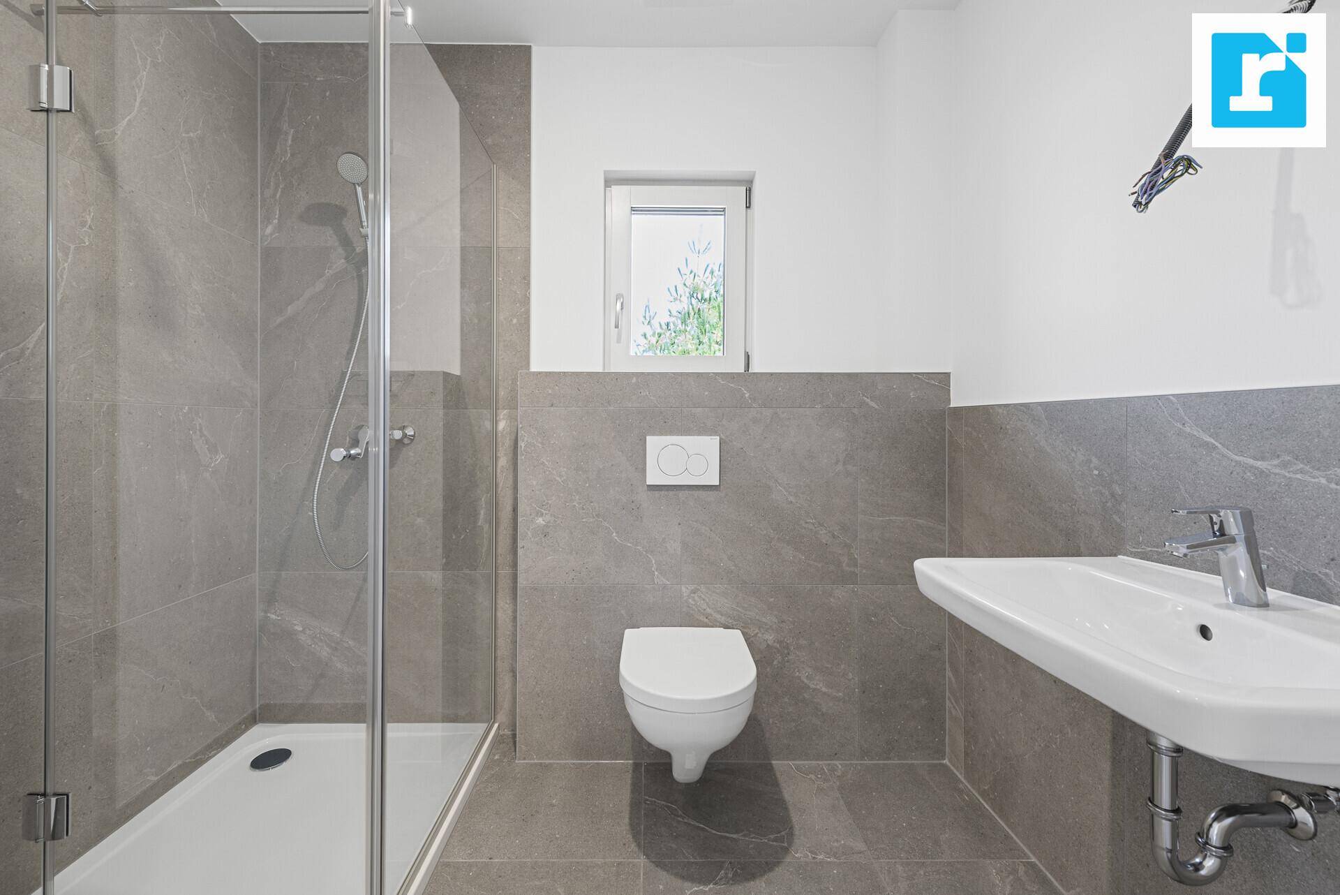 Helles Badezimmer mit Dusche, WC und Waschbecken in modernem Design.