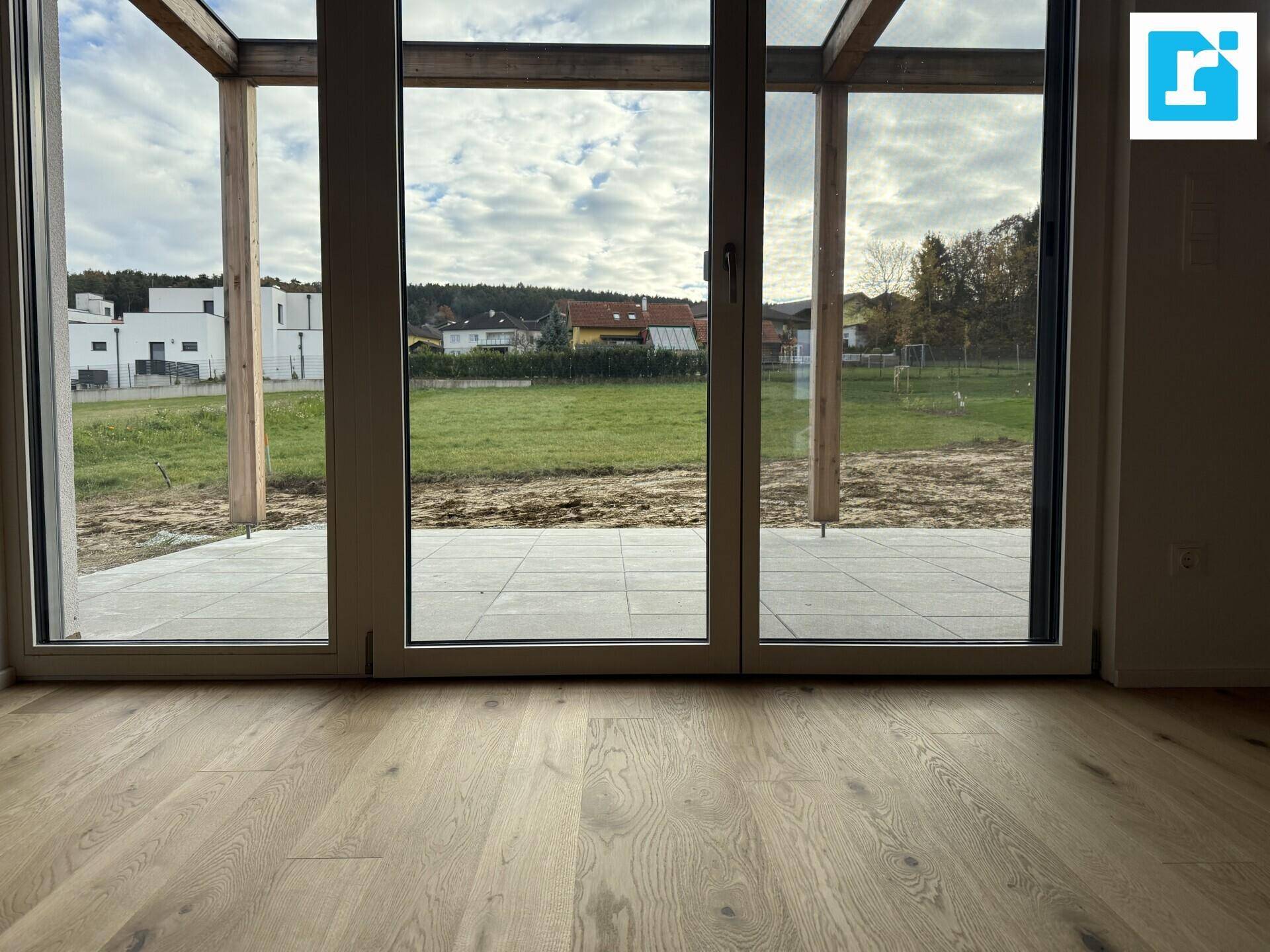 Große Terrassentüren bieten Zugang zum Außenbereich und weiten Blick ins Grüne.