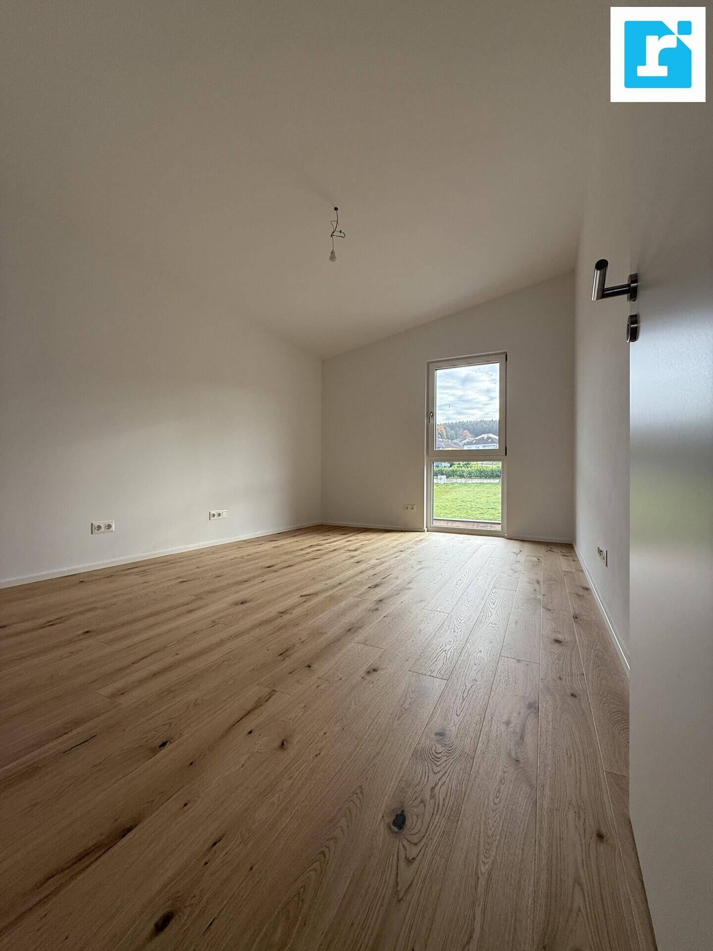 Geräumiges Schlafzimmer mit Parkettboden und schrägen Decken.