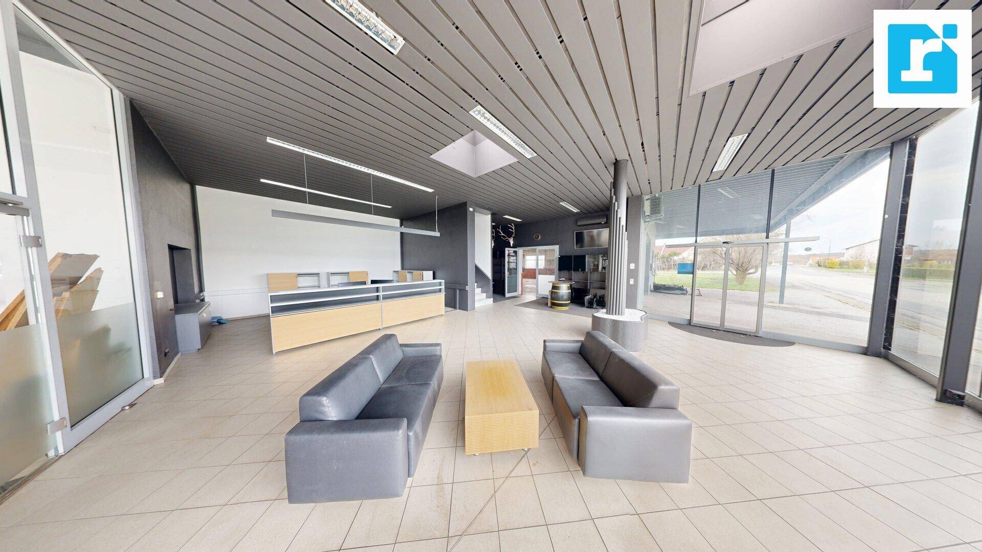 Moderner Wartebereich mit bequemen Sofas, Fliesenboden und Blick auf den Außenbereich.