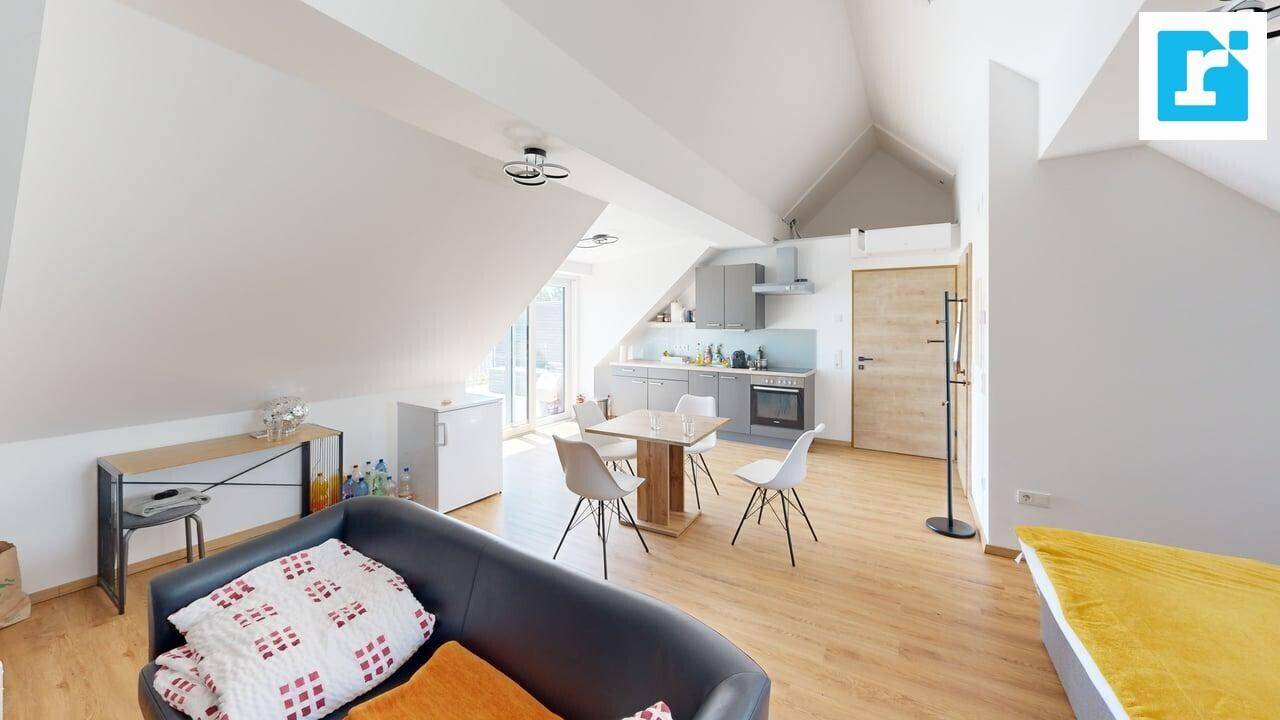 Offene Dachgeschosswohnung mit Wohn-, Ess- und Küchenbereich, modern eingerichtet und hell.