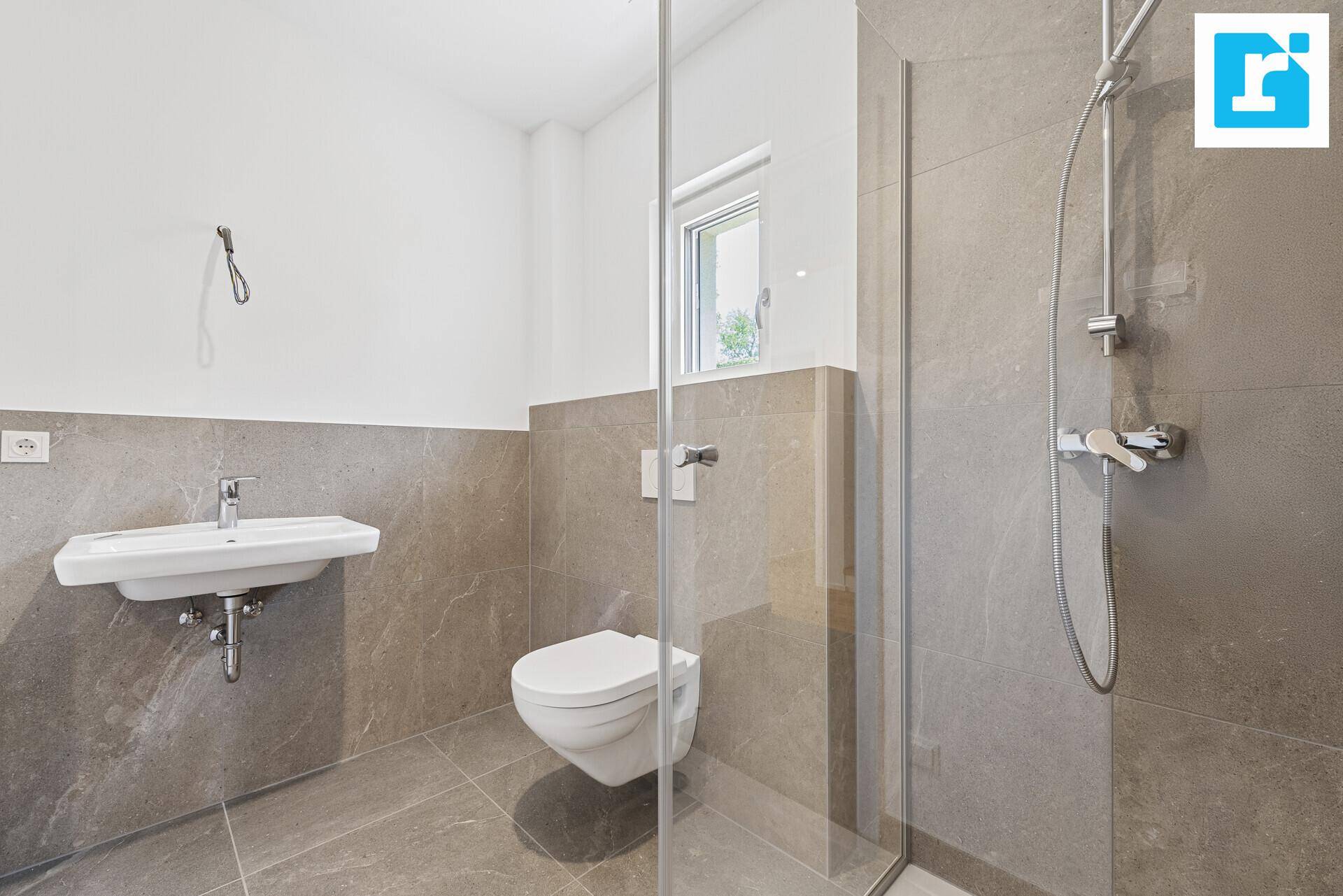Modernes Badezimmer mit ebenerdiger Dusche, Wand-WC und Fenster.