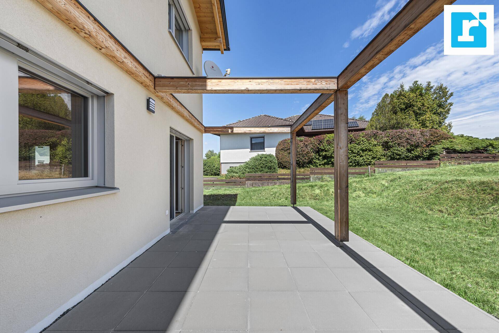 Sonniger Terrassenbereich mit Pergola und Zugang zum Garten, ideal für Entspannung.