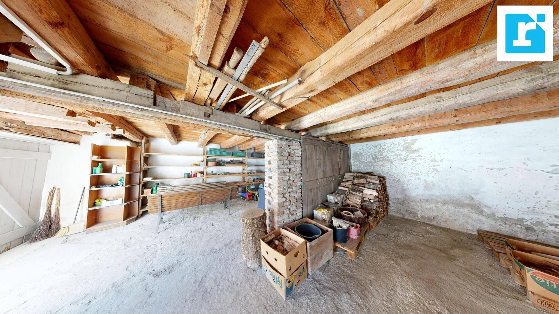Geräumiger Lagerraum mit sichtbaren Holzbalken, Regalen und gelagertem Holz.