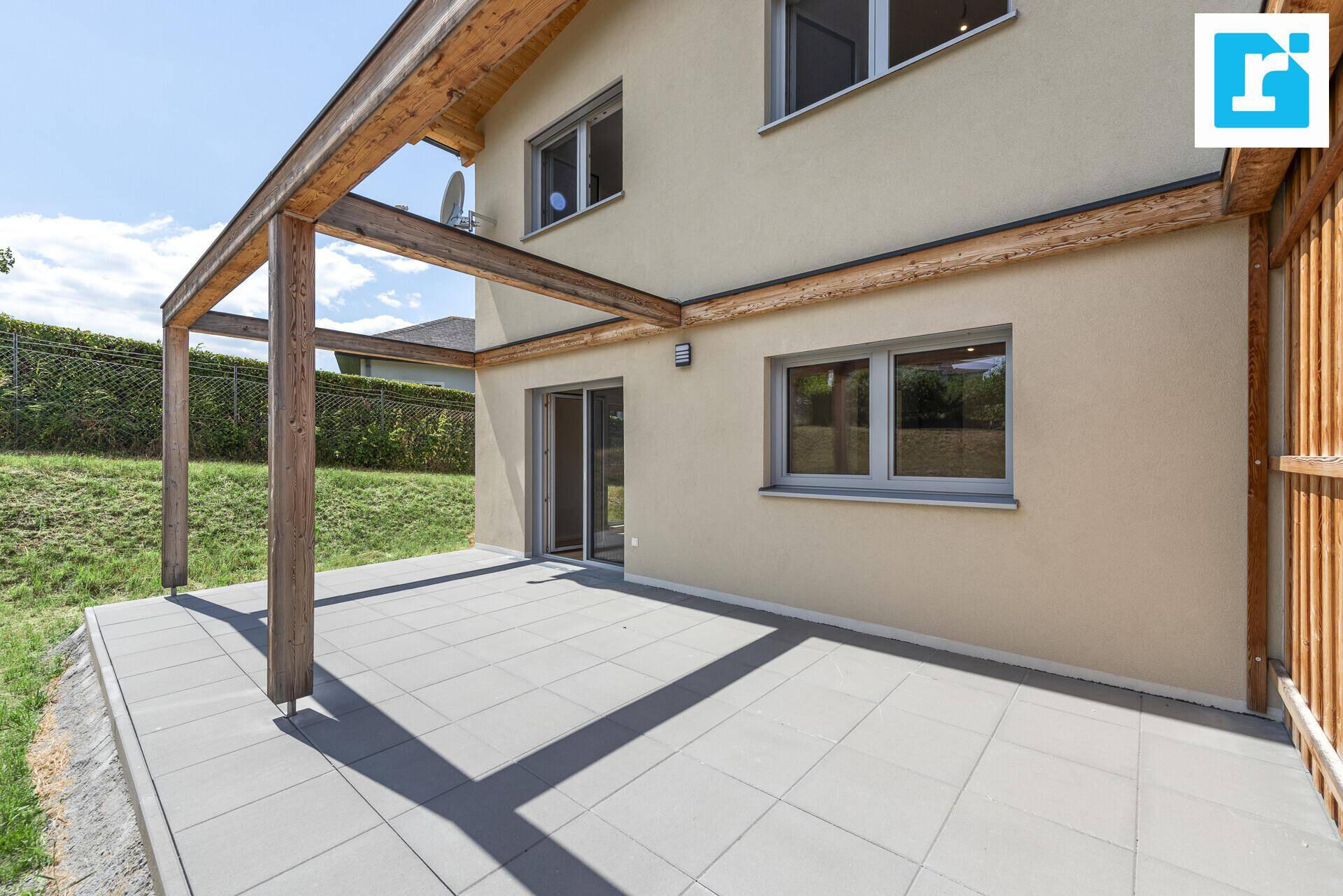 Großzügige Terrasse mit Holzpergola und Zugang zu den Innenräumen.