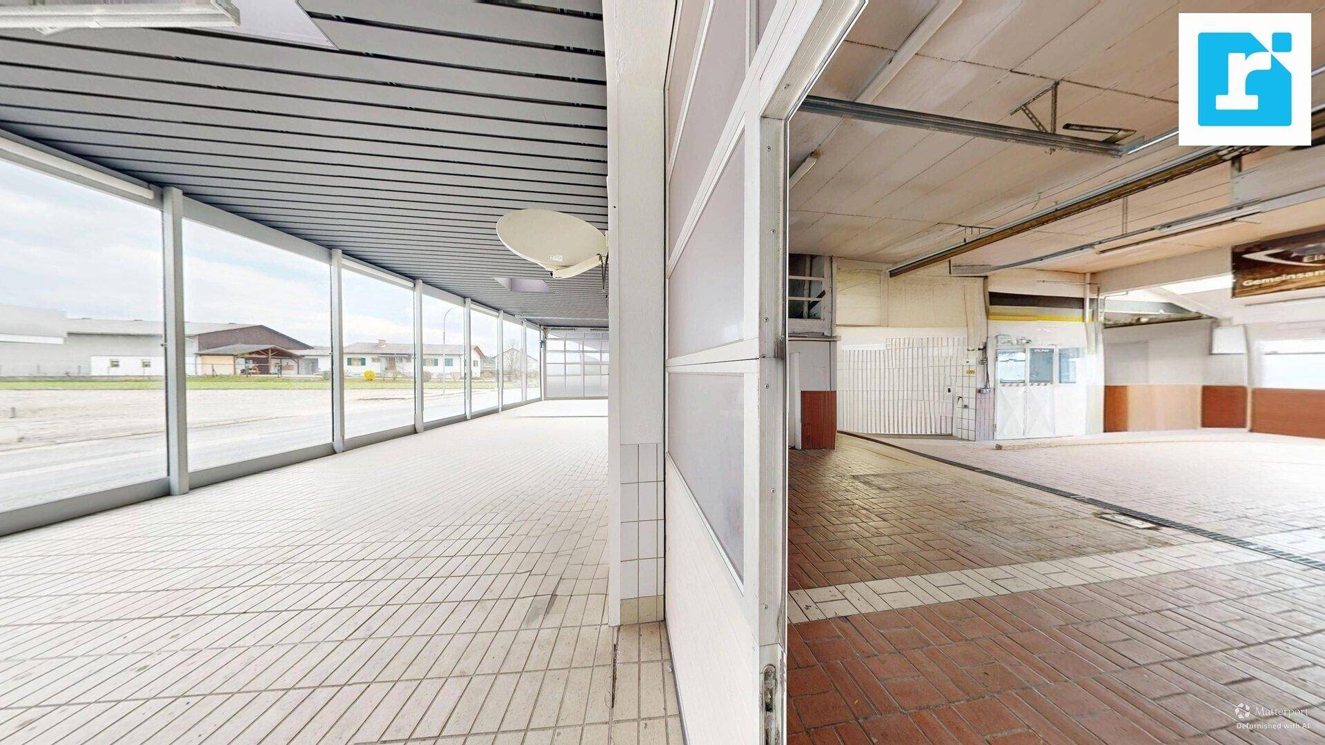 Heller Werkstattbereich mit Fliesenboden und großen Fensterfronten, bietet viel Tageslicht.