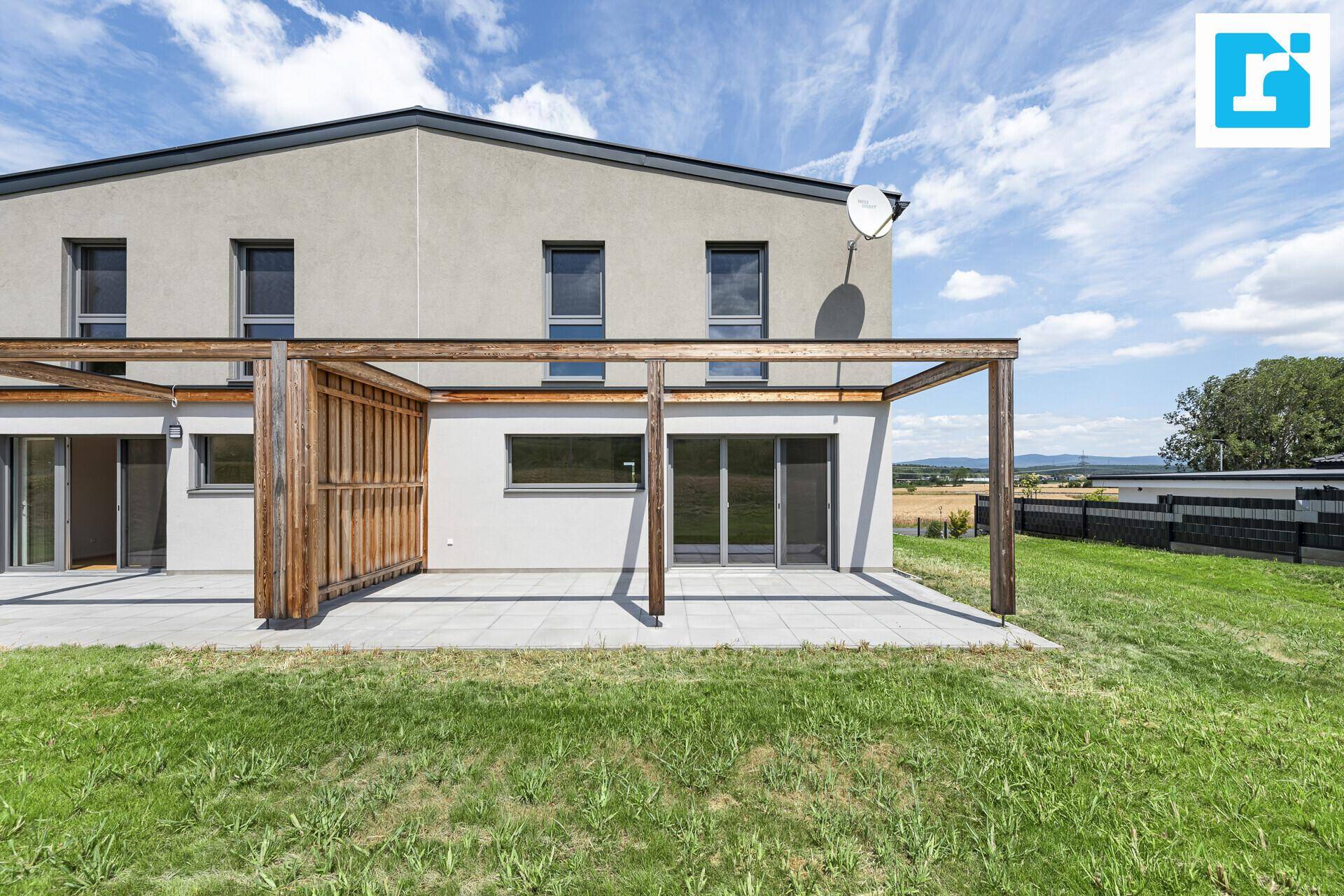Geräumige Terrasse mit Holzpergola und direktem Zugang zum Gartenbereich.