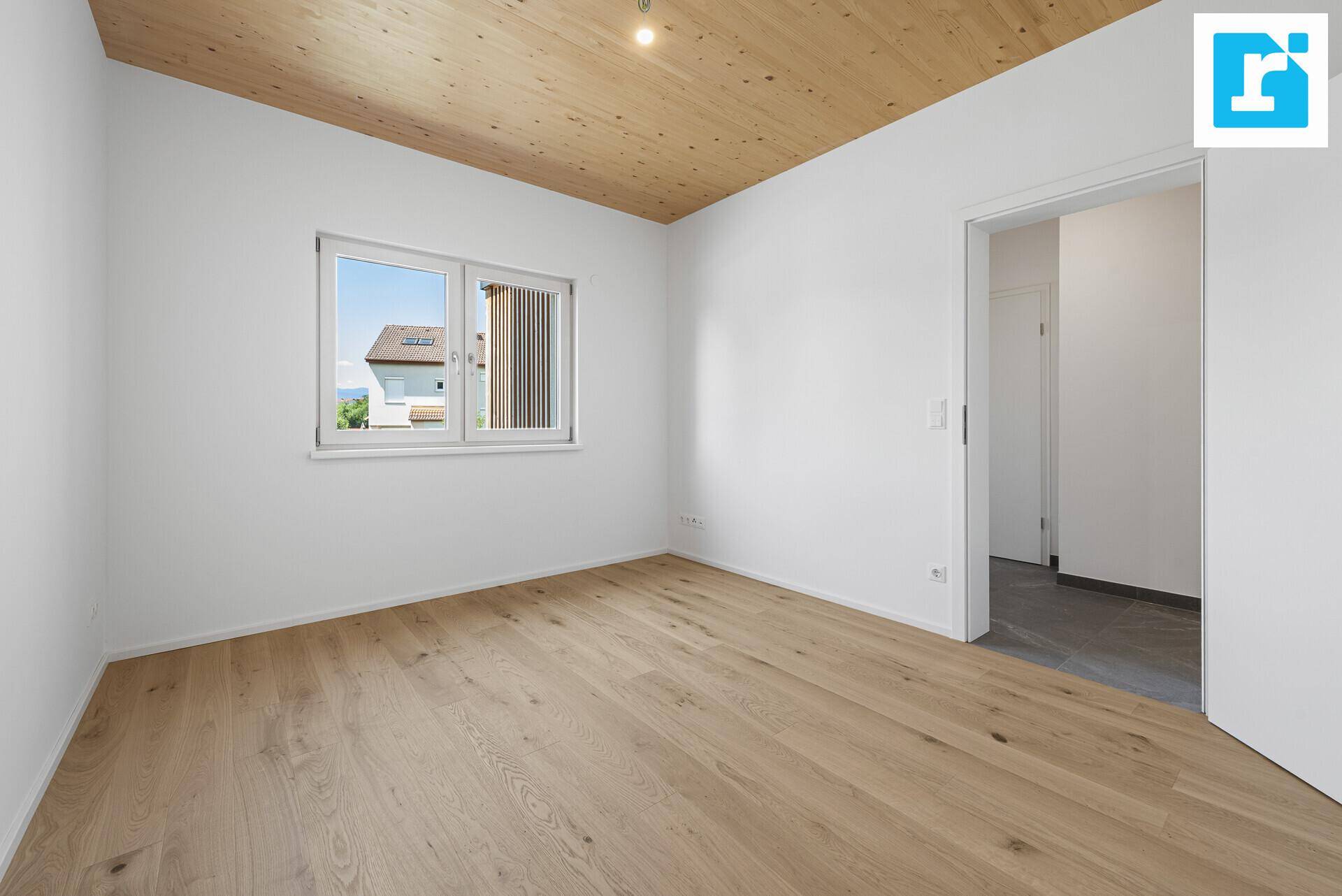 Geräumiges Schlafzimmer mit Parkettboden und Fenster, das viel Tageslicht hereinlässt.