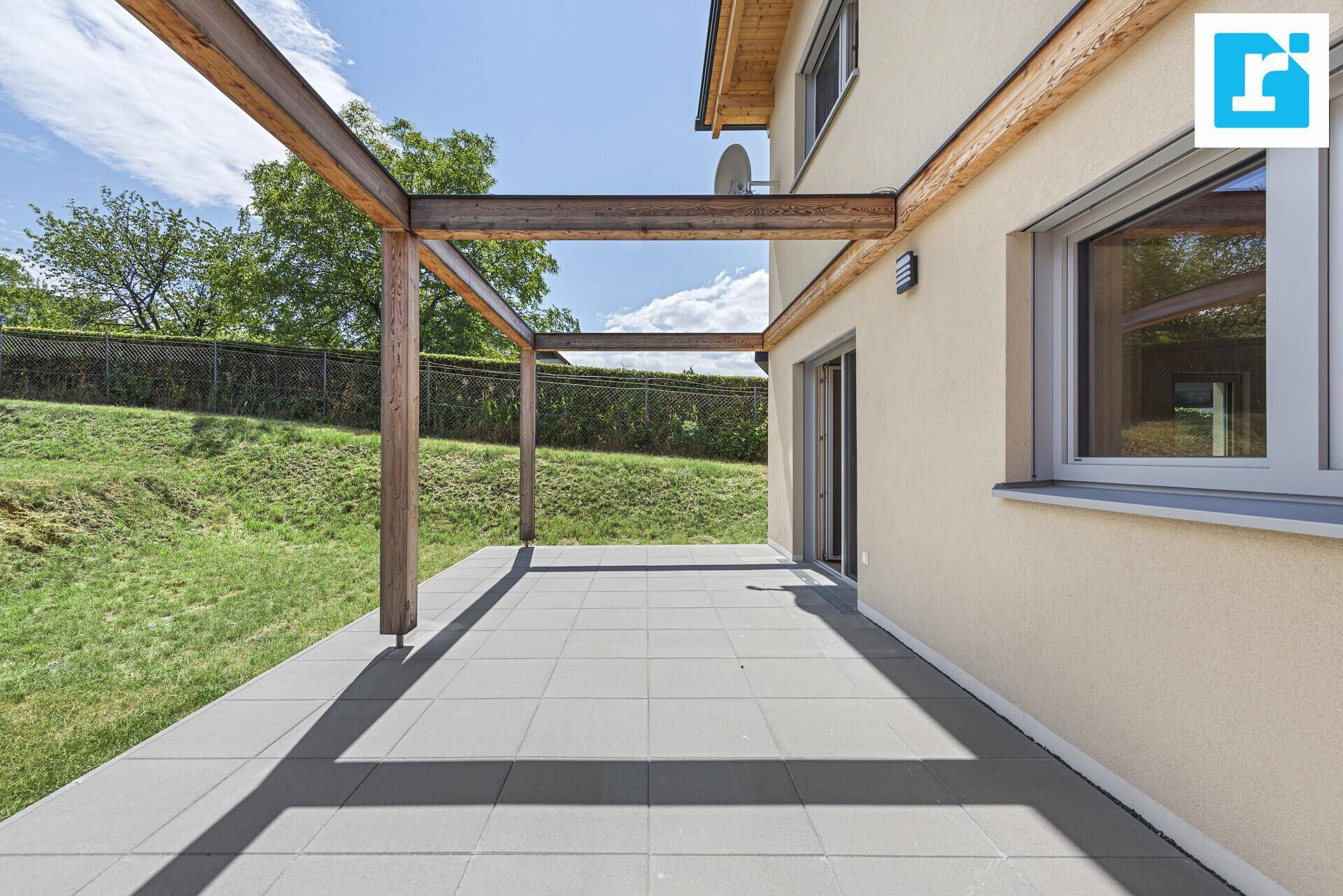 Geräumige Terrasse mit Holzpergola und direktem Zugang zum Garten.