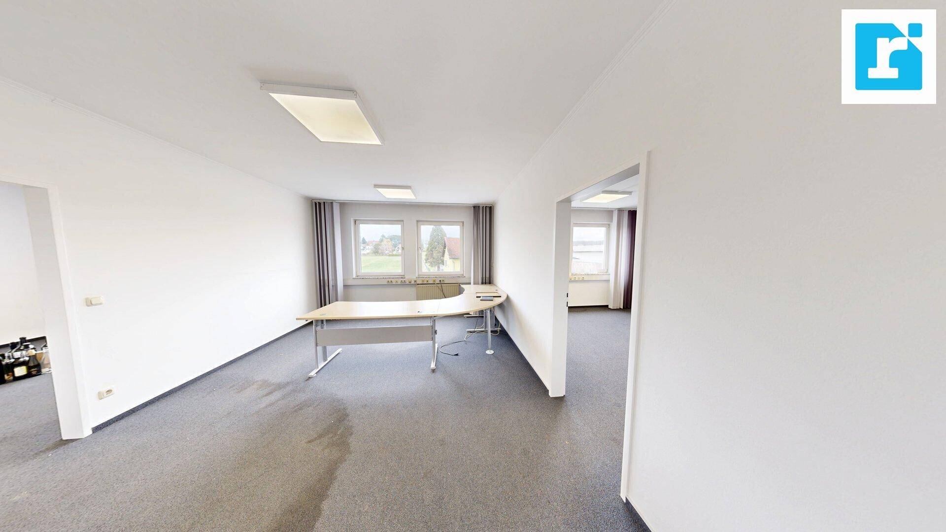 Geräumiges Büro mit Teppichboden und Fenstern, bietet viel Platz für Arbeitsplätze.