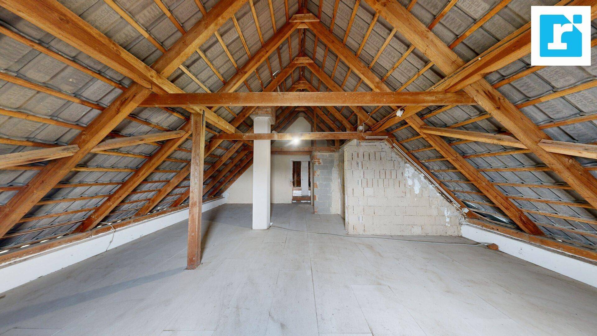 Großer Dachboden mit freiliegenden Holzbalken und Dachschrägen, bereit für den Ausbau.