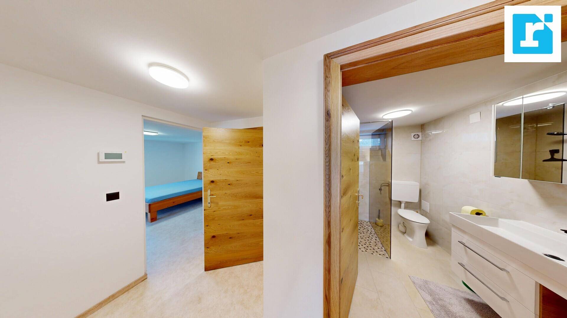 Heller Flur mit Zugang zu Schlafzimmer und modernem Badezimmer mit begehbarer Dusche.
