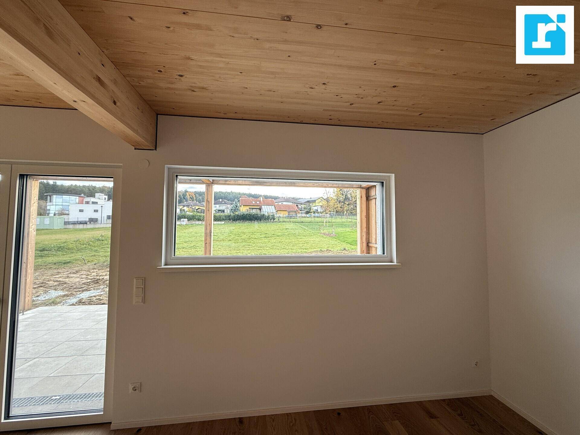 Großes Fenster im Wohnbereich mit Ausblick auf die umliegende Landschaft.