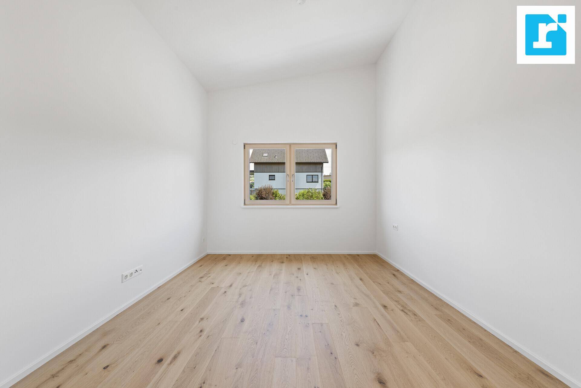 Schlichtes Zimmer mit Parkettboden und Fenster, ideal als Schlaf- oder Arbeitszimmer.