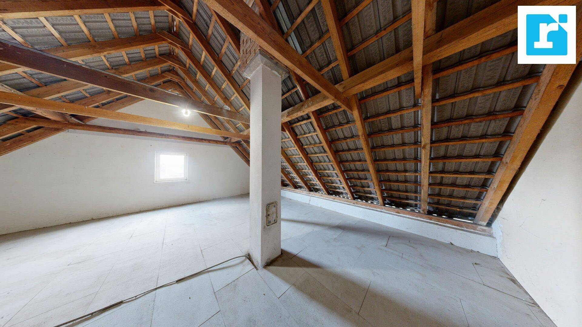 Geräumiger Dachboden mit sichtbaren Holzbalken und Dachschrägen, ideal für Ausbau.