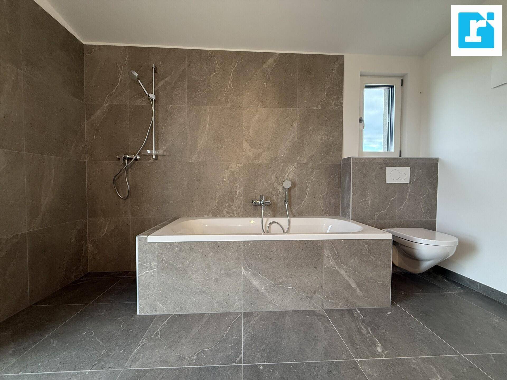 Modernes Badezimmer mit Badewanne und wandhängendem WC.
