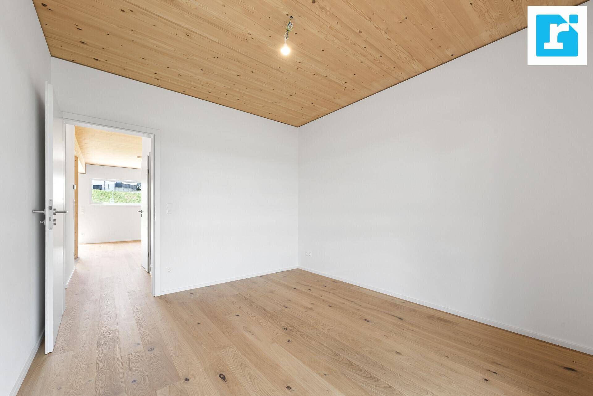Unmöbliertes Zimmer mit Holzbalkendecke und Parkettboden, bereit zum Einzug.