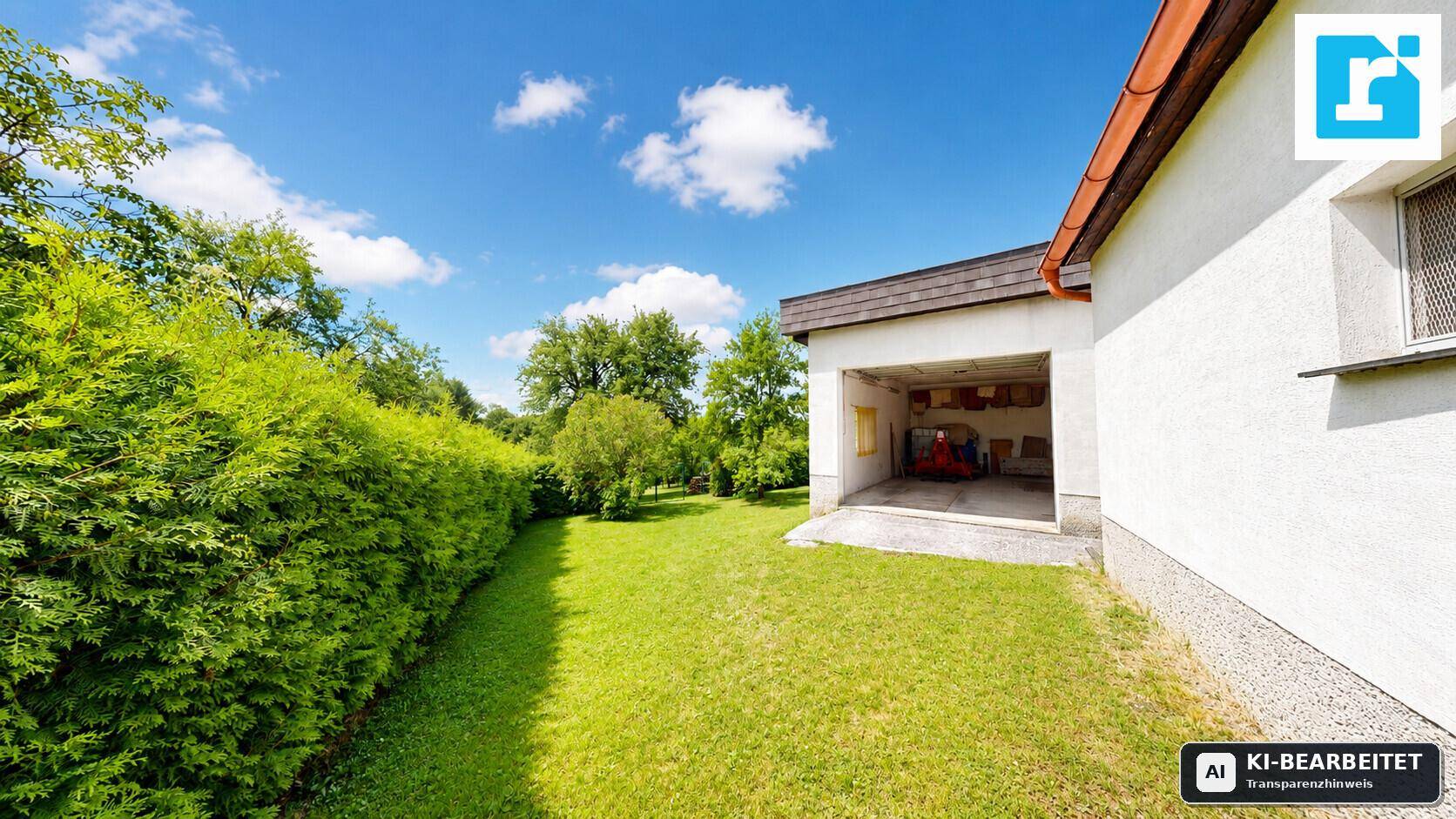 Großer Garten mit Rasenfläche, Hecke und offener Garage.