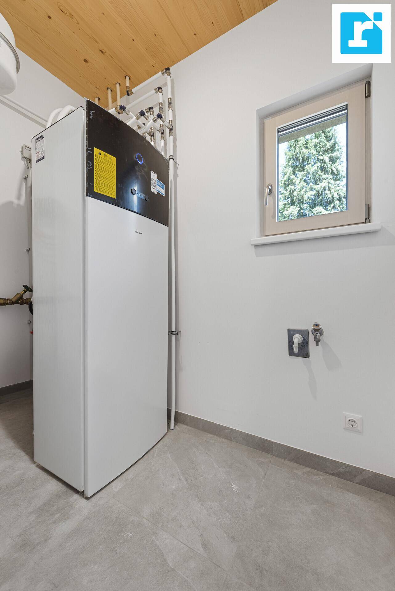 Hauswirtschaftsraum mit moderner Wärmepumpe und Fenster für Belüftung.