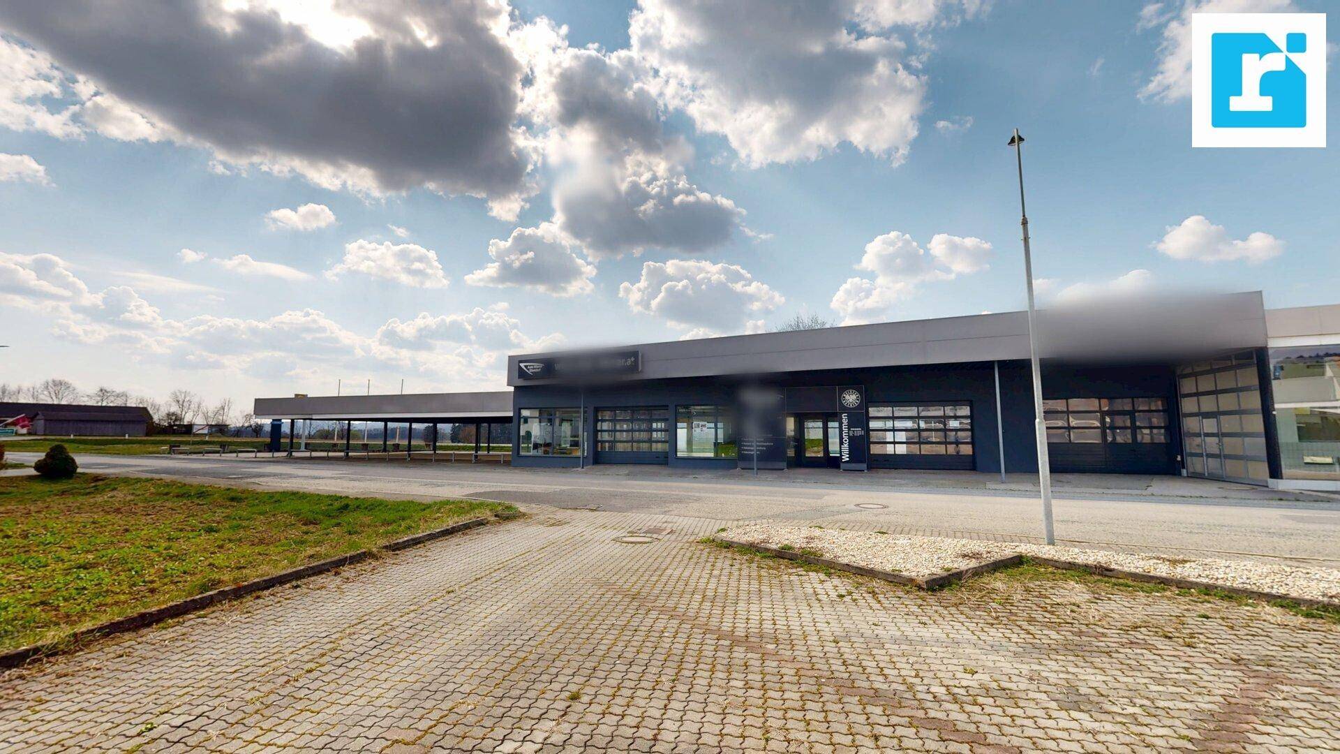 Ansicht des modernen Geschäftsgebäudes mit großen Glasfronten und weitläufigem Vorplatz.