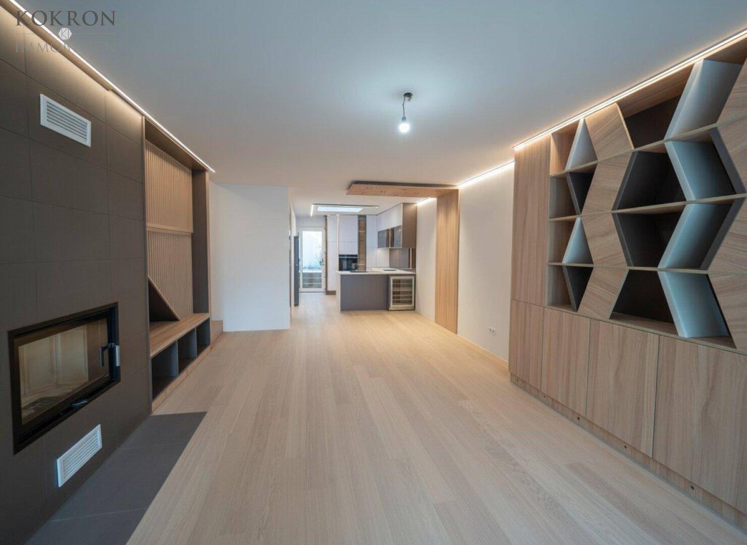Offener Wohn- und Essbereich mit Kamin, Holzboden und modernen Einbauten für ein gemütliches Ambiente.