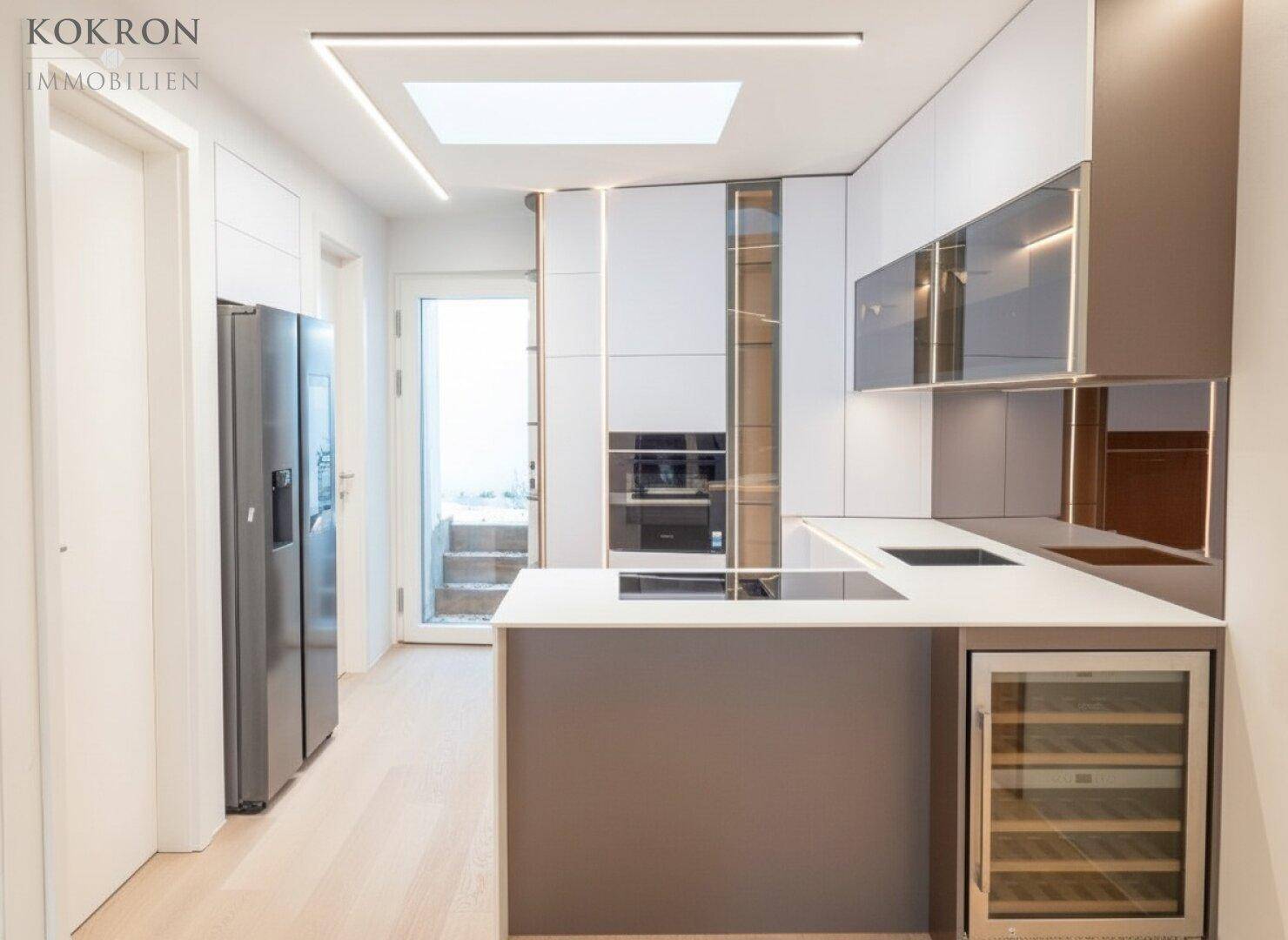 Moderne Küche mit Kochinsel, Weinkühler und großem Kühlschrank, ideal für Hobbyköche.