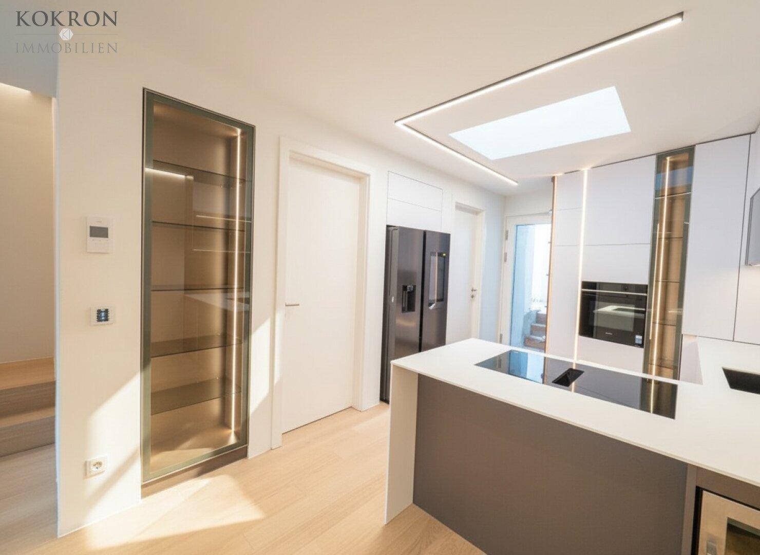 Helle Küche mit modernen Geräten, integriertem Kühlschrank und Oberlicht für optimale Beleuchtung.