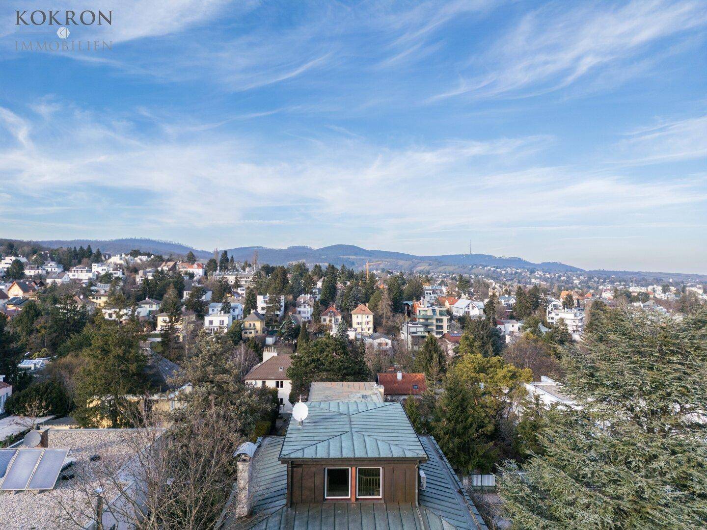 Panoramablick über die Wohngegend mit vielen Häusern und einer weiten Landschaft im Hintergrund.